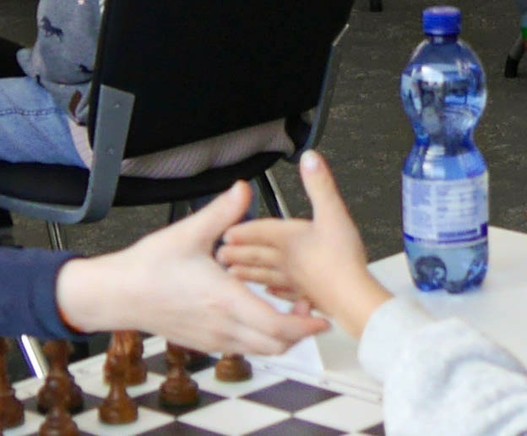 Zwei Hände beim missglückten Handshake vor Partiebeginn: Eine Person streckt die rechte, die andere Person die linke Hand aus.