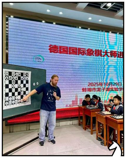 Luis vor einem Demobrett, wie er chinesischen Kindern Schach erklärt.